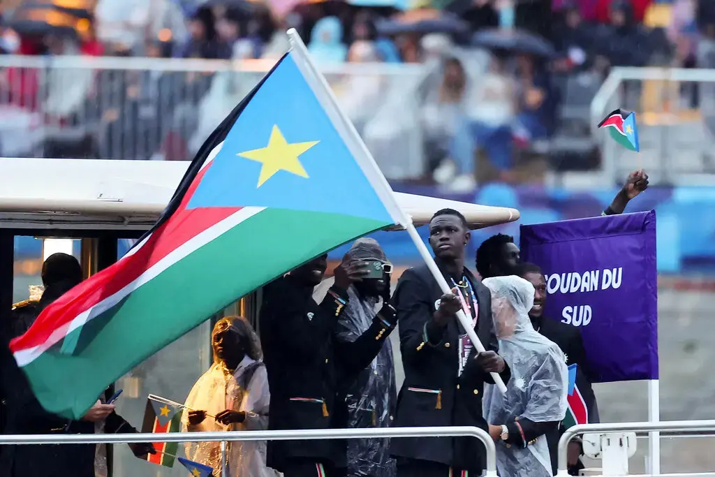 Team South Sudan in black double-breasted suits, with gold buttons and graphic details